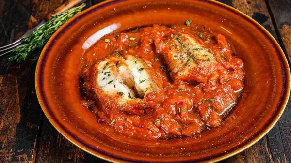 Хек, запеченный в томате с овощами: простой рецепт