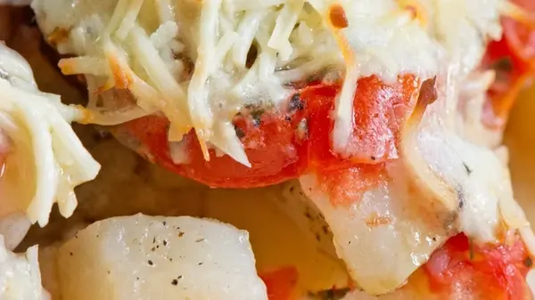 Картофель с курицей, помидорами и сыром, запеченный в лодочках из пергамента: рецепт эффектного блюда